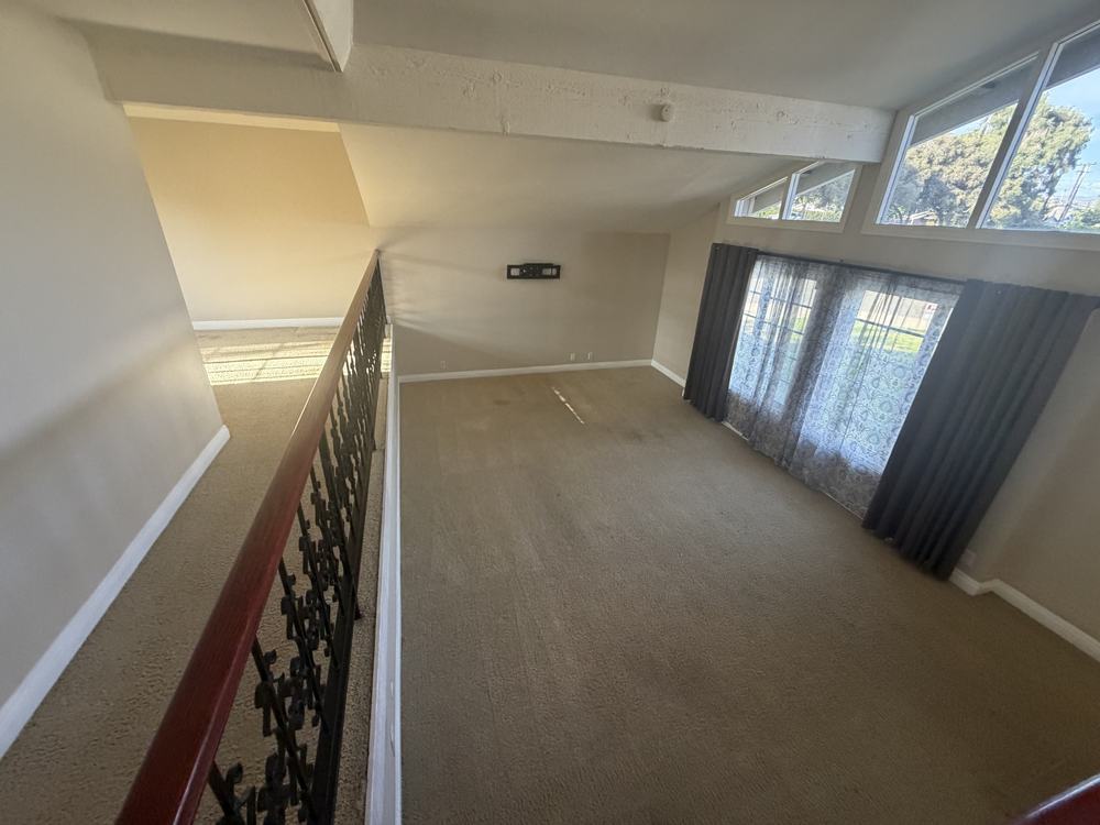 The same loft living room empty, with the carpet swept, after our team cleared it