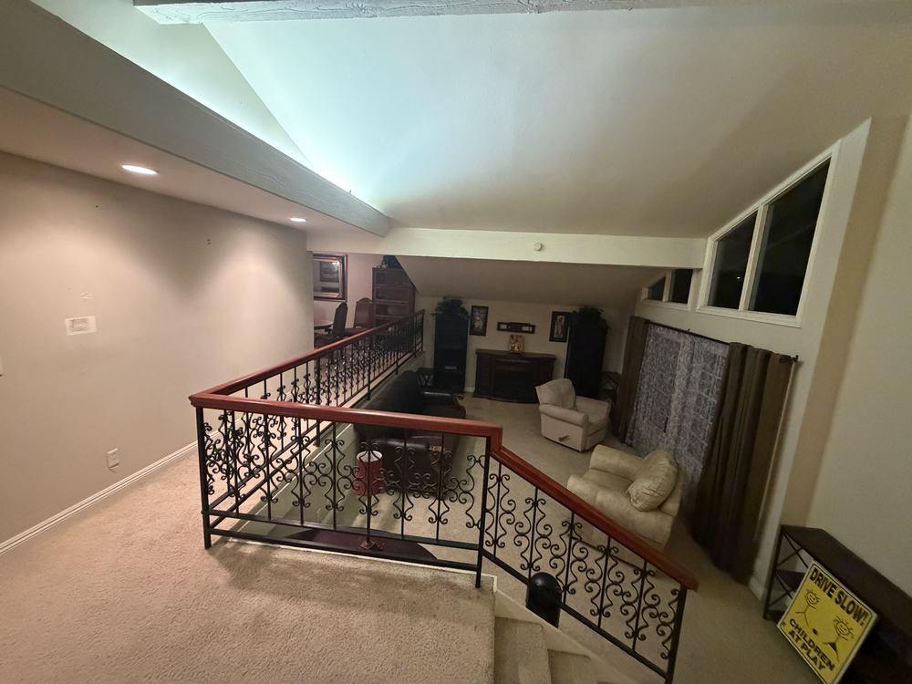 A loft living room full of sofas, armchairs and a TV console before our team cleared it